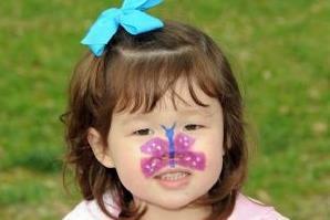 Young girl with butterfly painted on face.